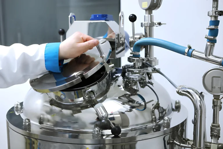 Pharmaceutical CDMO manufacturing reactor with technician operating stainless steel production vessel